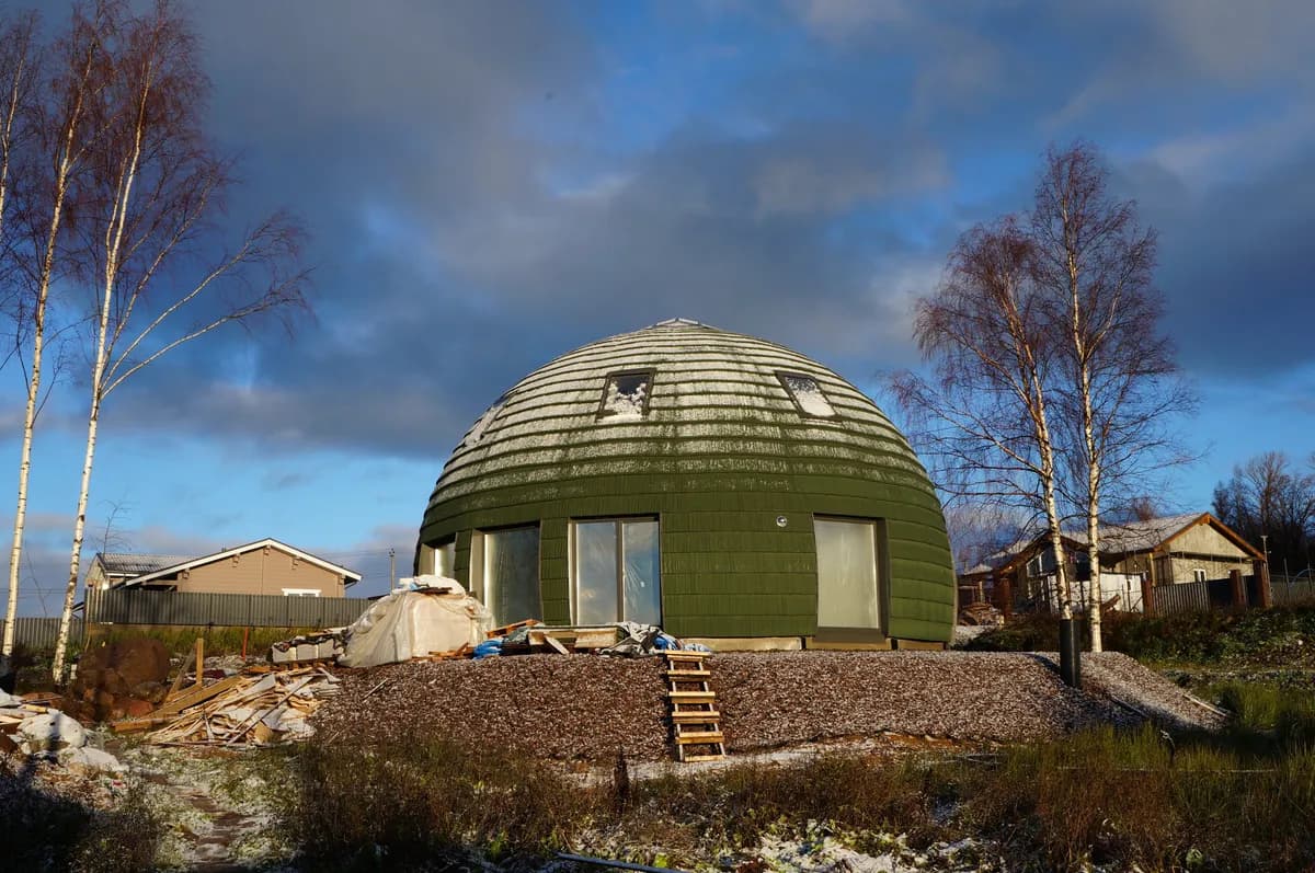 BookNoFees exempelbild: Grönt kupolhus under blå himmel på en grönskande tomt