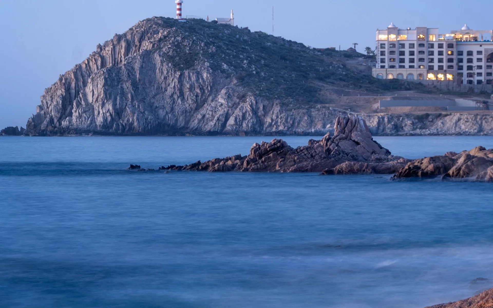 Klippig kust med fyr vid Cabo San Lucas