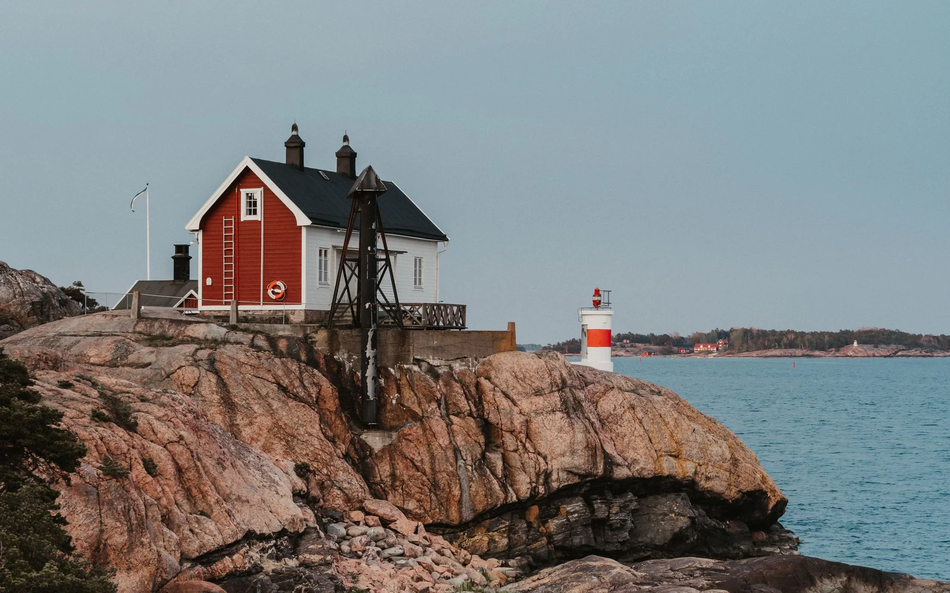Rött hus och fyr vid Sveriges klippkust