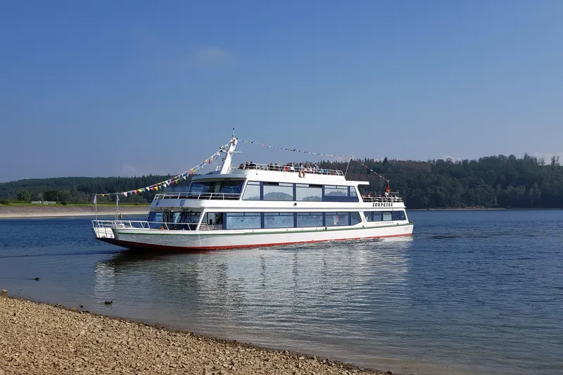 Passagerarbåten MS Sorpesee på sjön nära Sundern, med skog på den motsatta stranden