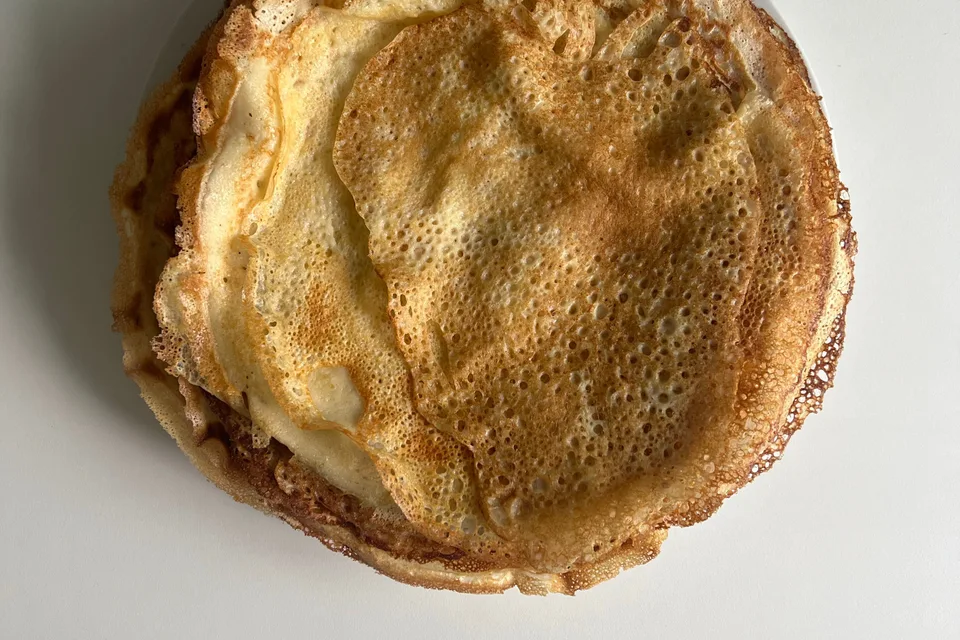 BookNoFees: Exempelbild: Tunna gyllene pannkakor på en vit tallrik